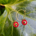 boucles d'oreilles créoles doré avec un pendentif rouge orné d'une étoile doré