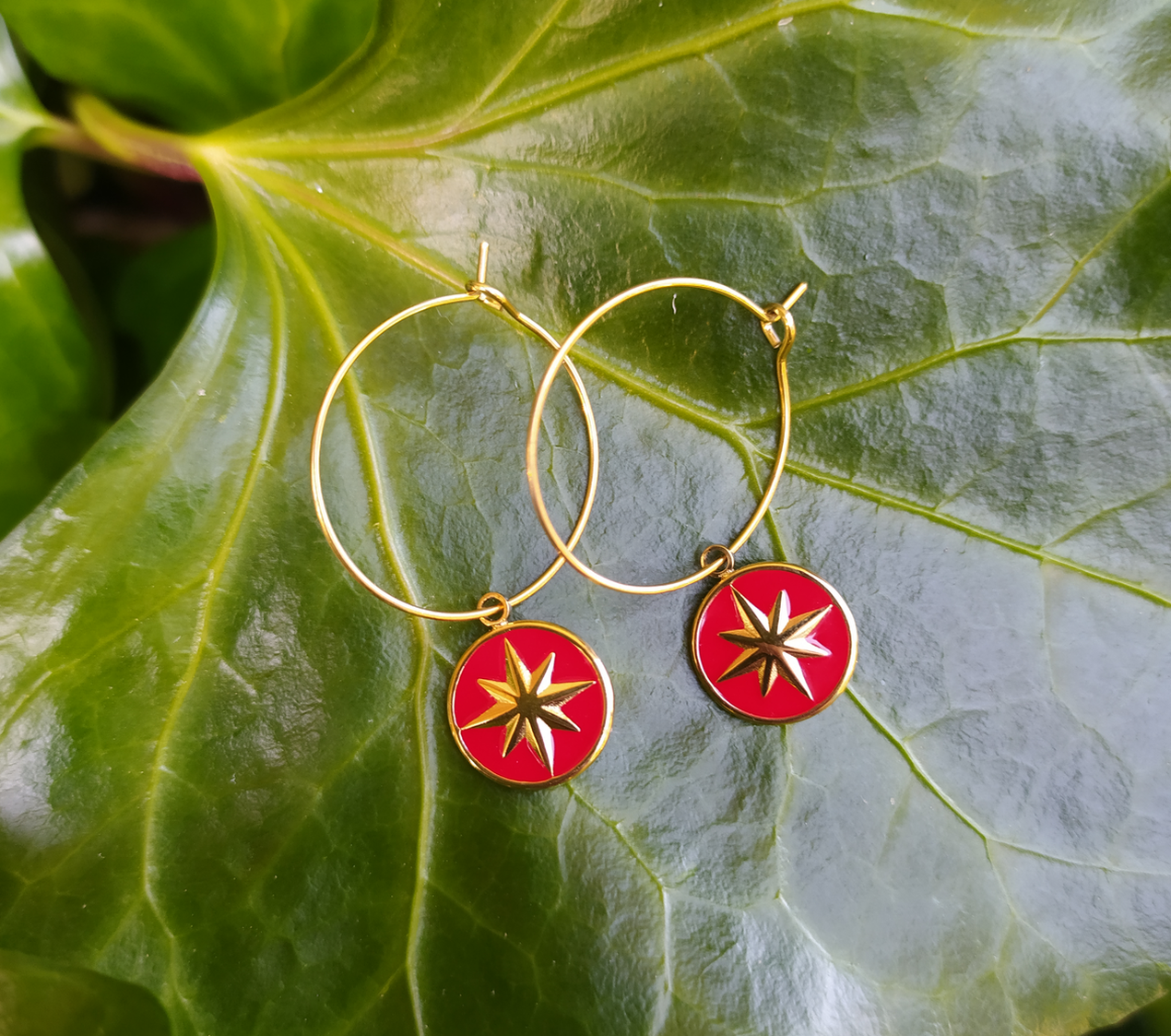 boucles d'oreilles créoles doré avec un pendentif rouge orné d'une étoile doré