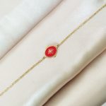 bracelet en acier inoxydable doré avec un pendentif rouge orné d'une étoile