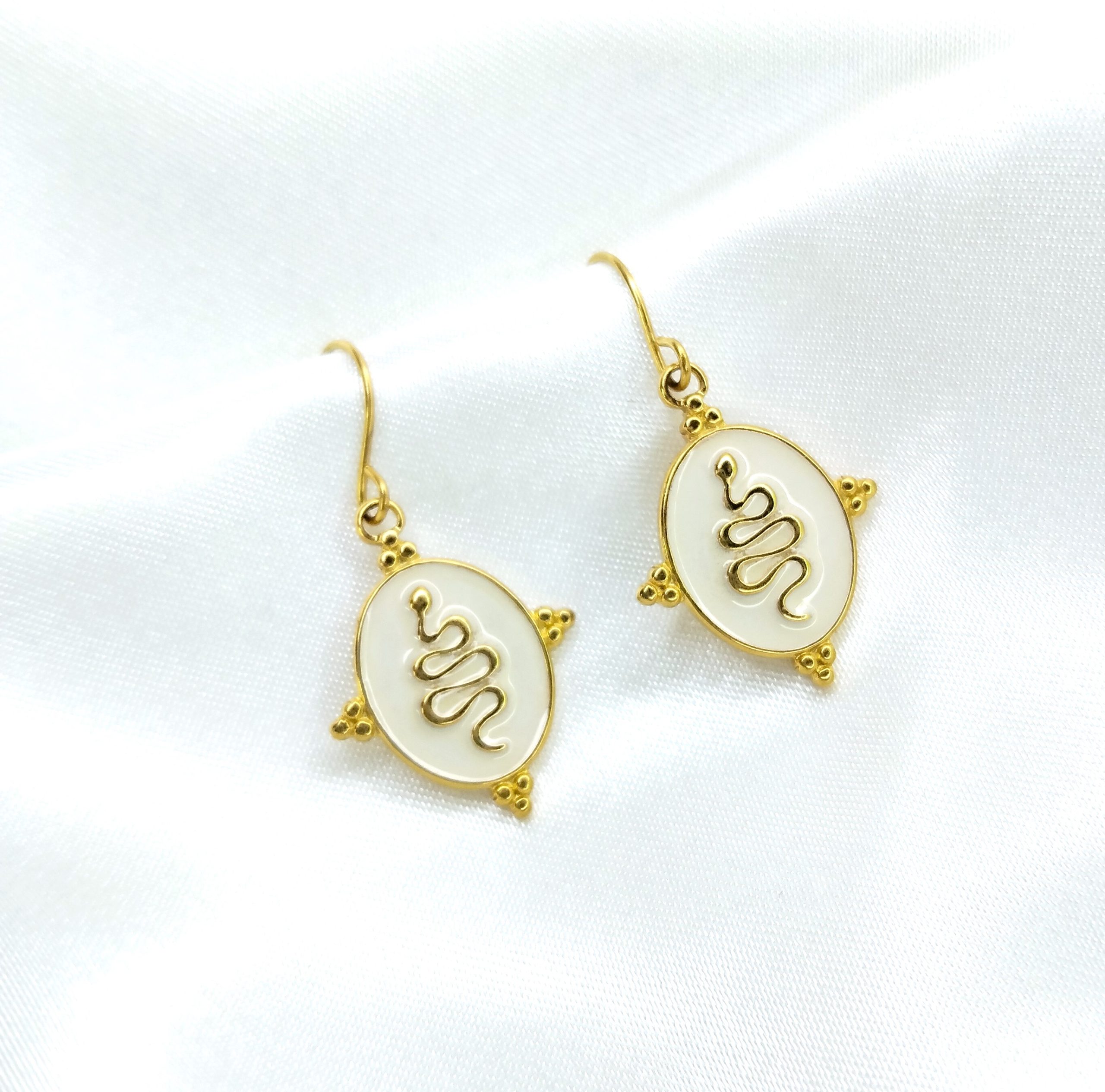 Boucles d'oreilles Sofia serpent doré sur fond blanc