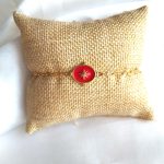 bracelet en acier inoxydable doré avec un pendentif rouge orné d'une étoile
